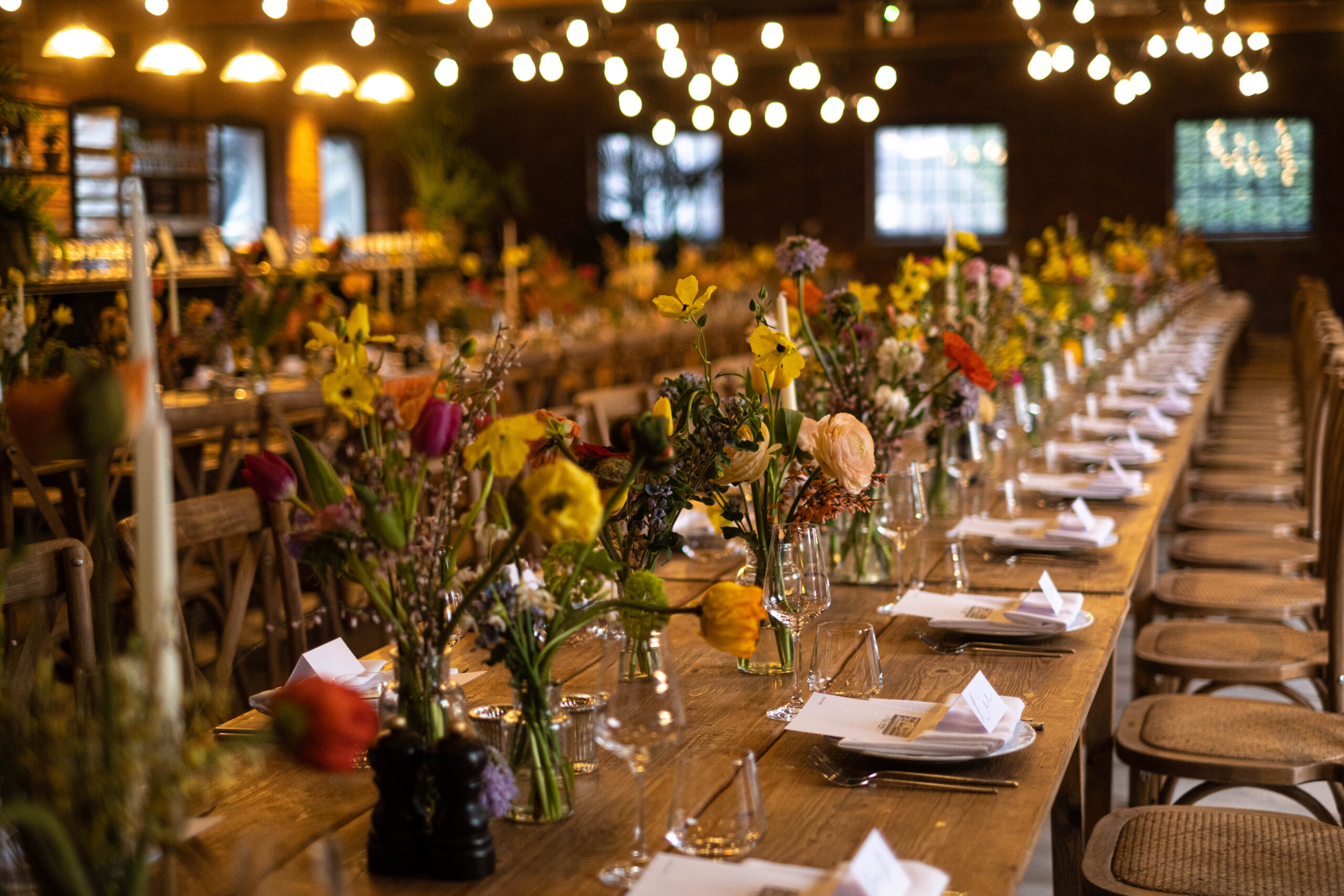 A long decorated table with flowers and place settings